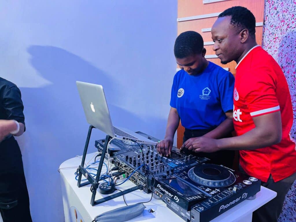 A student learns how to DJ using a mixing console and computer.
